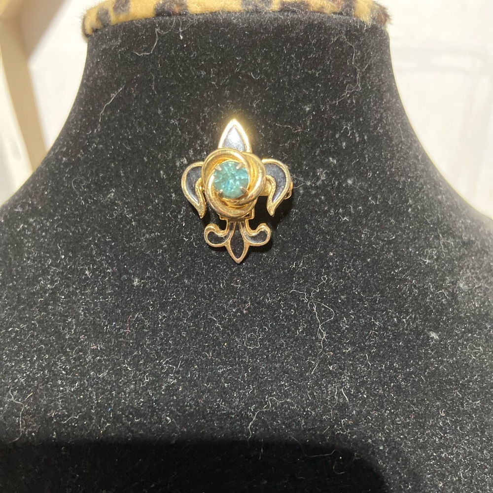 Vintage Gold Tone and Black Enamel Fleur De Lis with a Blue Center Rhinestone.